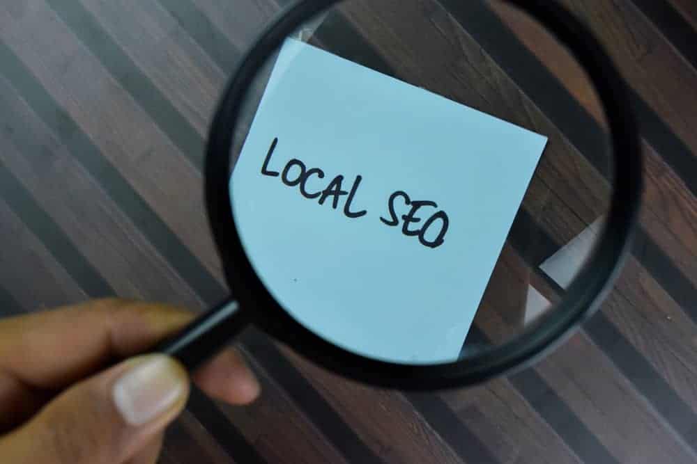 Magnifying Glass over sticky note with LOCAL SEO on it.