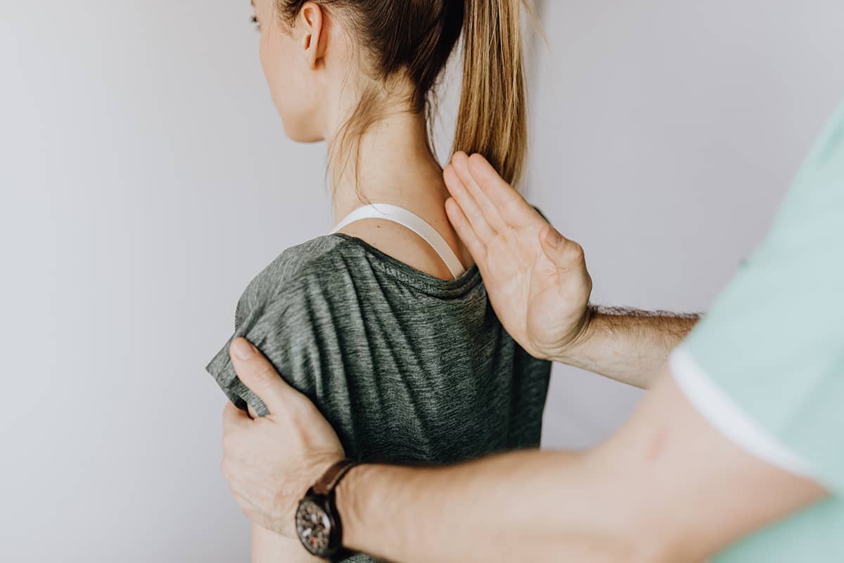 Woman having her spine realigned from a Chiropractor marketing director